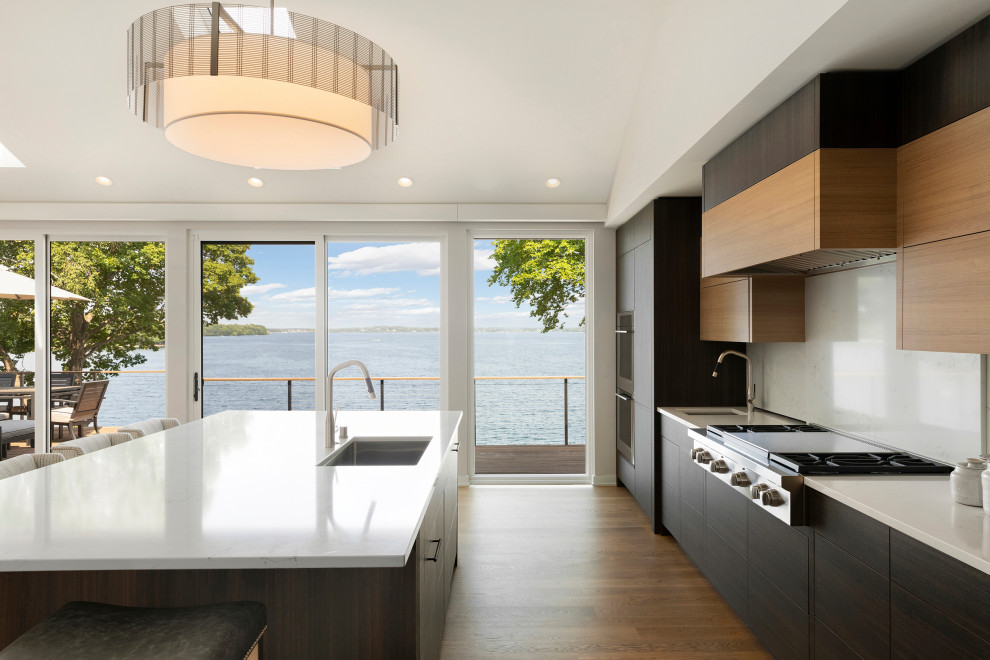Esempio di una cucina design con ante lisce, top bianco, lavello sottopiano, pavimento in legno massello medio, pavimento marrone e soffitto a volta