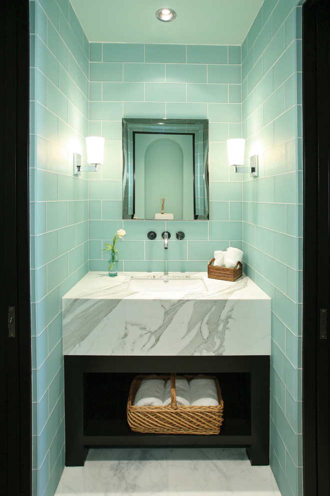 This is an example of a beach style powder room in Orange County with glass tile.