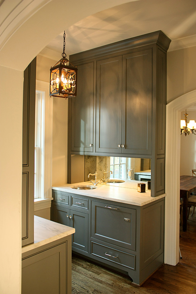 This is an example of a traditional single-wall wet bar in Nashville with a drop-in sink, shaker cabinets, green cabinets, marble benchtops, painted wood floors and white benchtop.