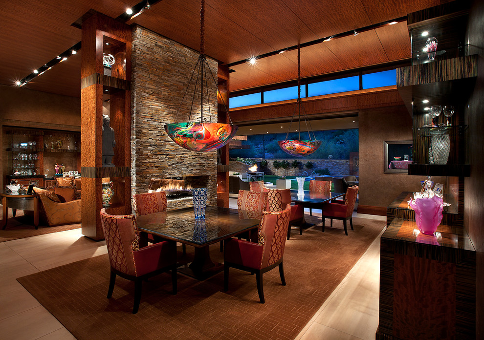Large contemporary open plan dining in Phoenix with brown walls, a two-sided fireplace, ceramic floors and a stone fireplace surround.