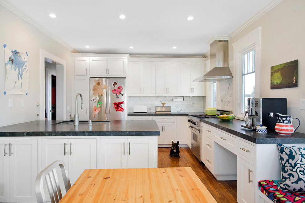 Inspiration for a mid-sized traditional l-shaped eat-in kitchen in San Francisco with an undermount sink, recessed-panel cabinets, white cabinets, granite benchtops, white splashback, stainless steel appliances, medium hardwood floors, with island, marble splashback, brown floor and grey benchtop.