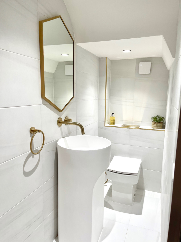 Inspiration for a small modern cloakroom in London with white cabinets, a one-piece toilet, white tiles, porcelain tiles and a freestanding vanity unit.