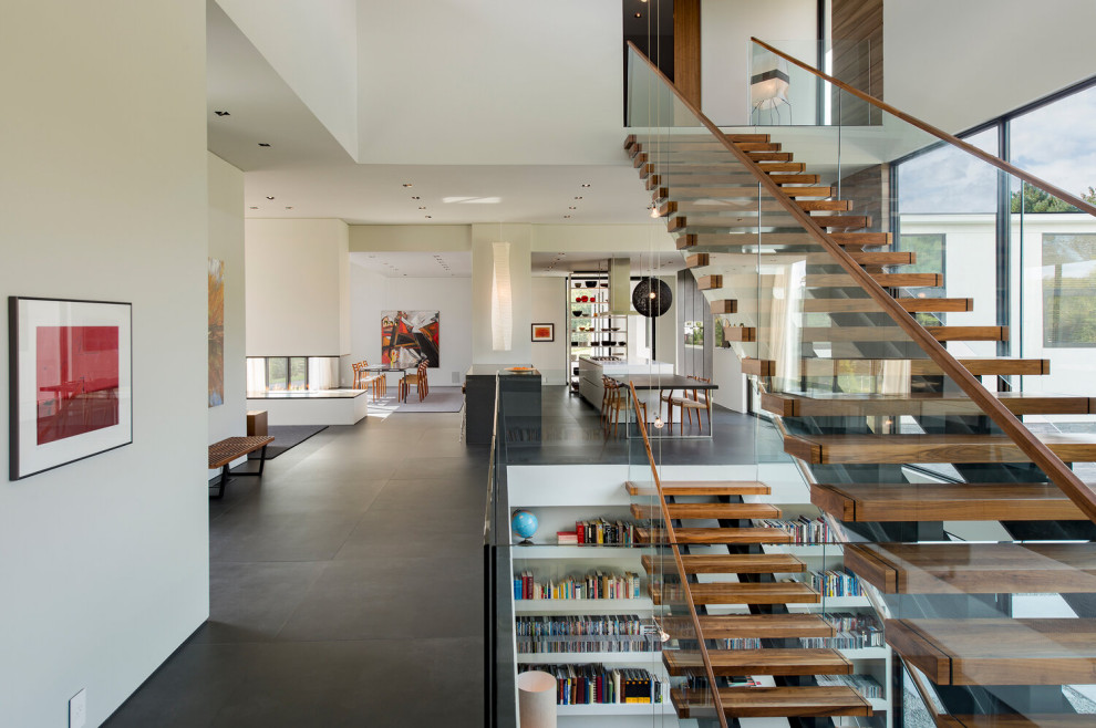 Inspiration for an expansive contemporary wood floating staircase in DC Metro with open risers and glass railing.