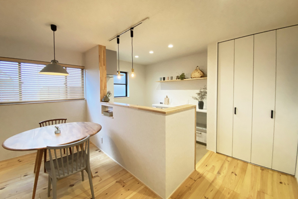 На фото: параллельная кухня с паркетным полом среднего тона, бежевым полом, белой столешницей и потолком с обоями