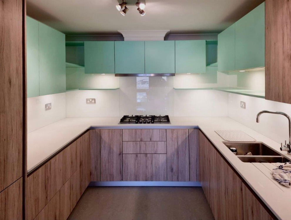 Ejemplo de cocinas en L contemporánea pequeña cerrada con armarios con paneles lisos, puertas de armario verdes y salpicadero blanco