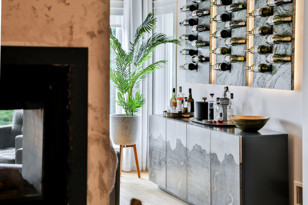 Imagen de bar en casa lineal con armarios con paneles lisos, puertas de armario grises, suelo de madera clara y encimeras grises