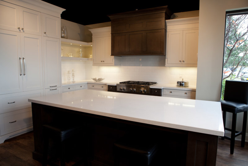Example of a large transitional l-shaped dark wood floor and brown floor eat-in kitchen design in Toronto with stainless steel appliances, an island, shaker cabinets, white cabinets, quartzite countertops, white backsplash and subway tile backsplash