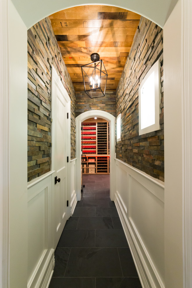 Design ideas for a mid-sized country wine cellar in New York with slate floors, storage racks and black floor.