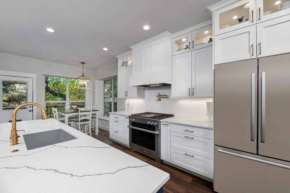 Eat-in kitchen - contemporary medium tone wood floor and brown floor eat-in kitchen idea with a single-bowl sink, shaker cabinets, white cabinets, quartz countertops, white backsplash, subway tile backsplash, stainless steel appliances, an island and white countertops