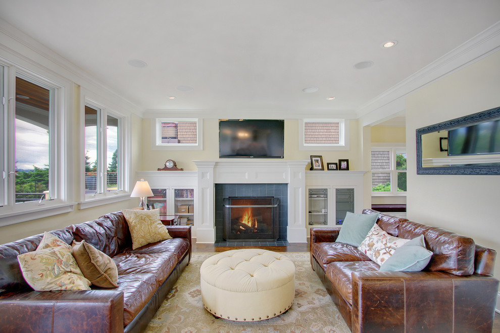 Design ideas for an arts and crafts living room in Seattle with yellow walls, a standard fireplace and a wall-mounted tv.
