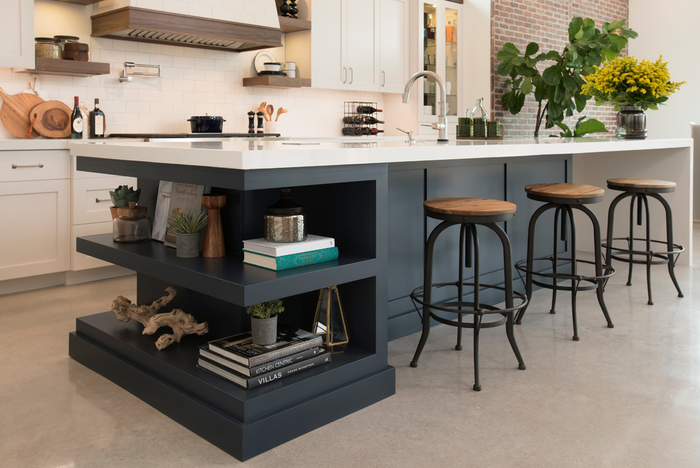 Inspiration for a mid-sized industrial l-shaped open plan kitchen in Miami with a double-bowl sink, shaker cabinets, blue cabinets, quartz benchtops, beige splashback, ceramic splashback, stainless steel appliances, concrete floors and with island.