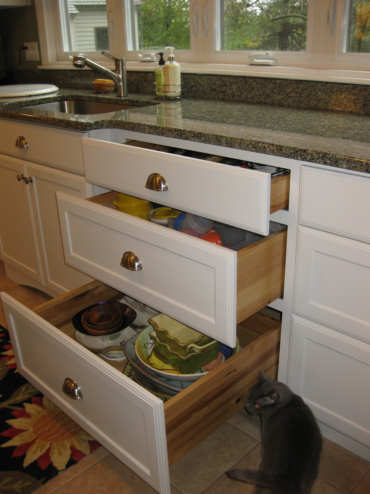 Transitional l-shaped ceramic tile and beige floor kitchen photo in Boston with an undermount sink, shaker cabinets, white cabinets, granite countertops, white appliances and green countertops