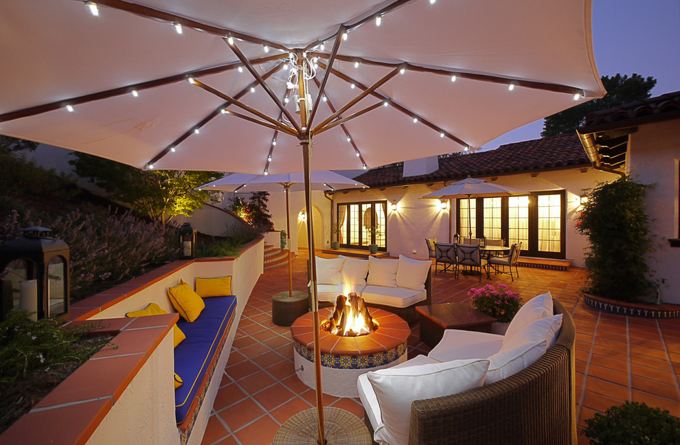This is an example of a mediterranean backyard patio in Los Angeles with a fire feature and tile.