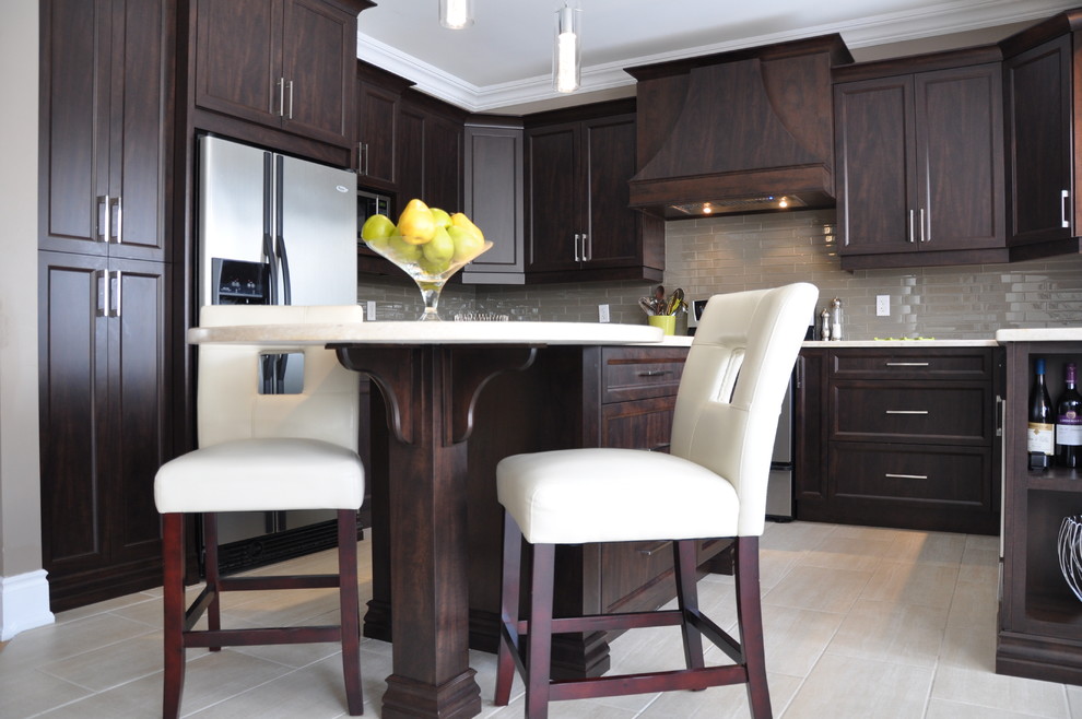 Example of a large transitional u-shaped ceramic tile open concept kitchen design in Ottawa with an undermount sink, shaker cabinets, dark wood cabinets, granite countertops, beige backsplash, glass tile backsplash, stainless steel appliances and an island