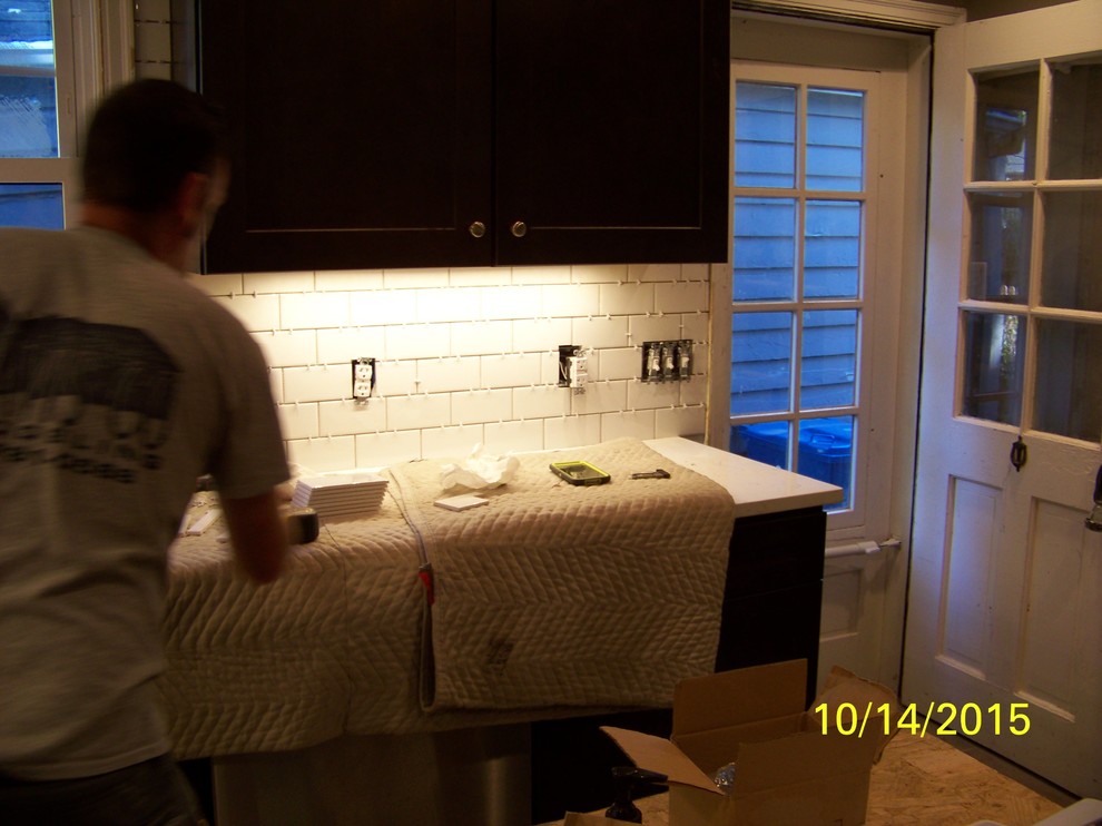 Inspiration for a mid-sized rustic u-shaped porcelain tile eat-in kitchen remodel in Indianapolis with a farmhouse sink, shaker cabinets, dark wood cabinets, wood countertops, white backsplash, ceramic backsplash, stainless steel appliances and an island