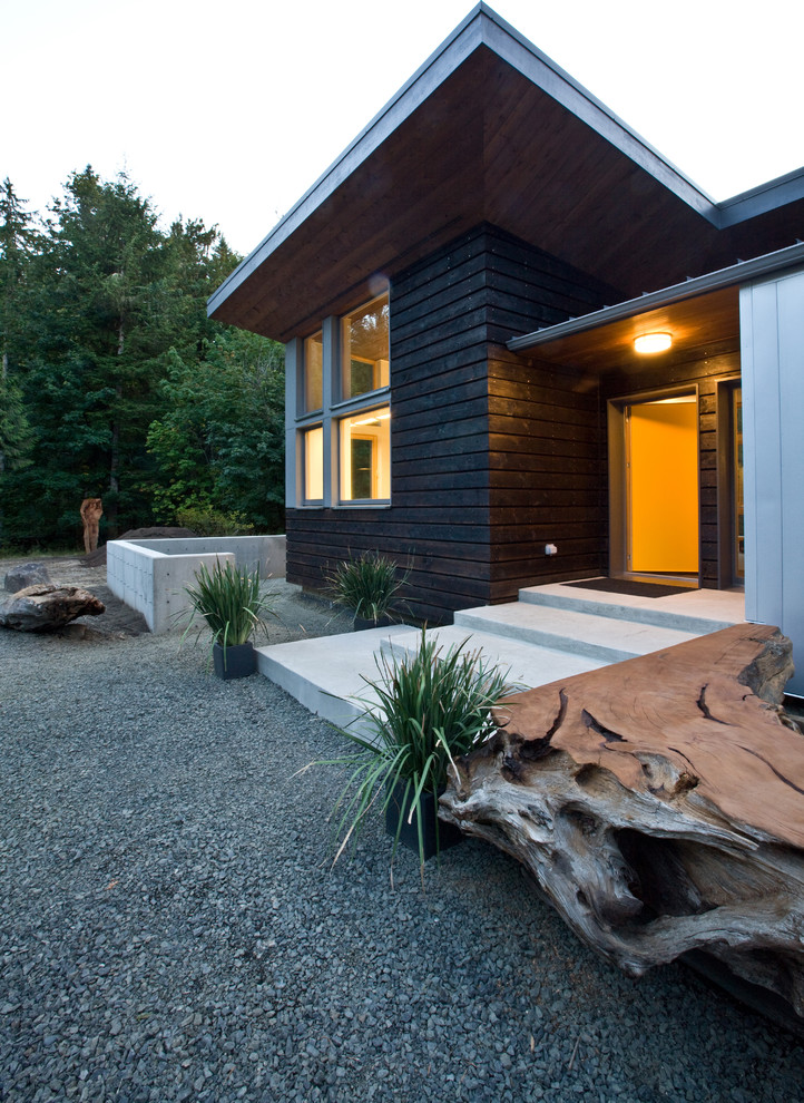 Photo of a large modern one-storey brown house exterior in Other with wood siding and a shed roof.