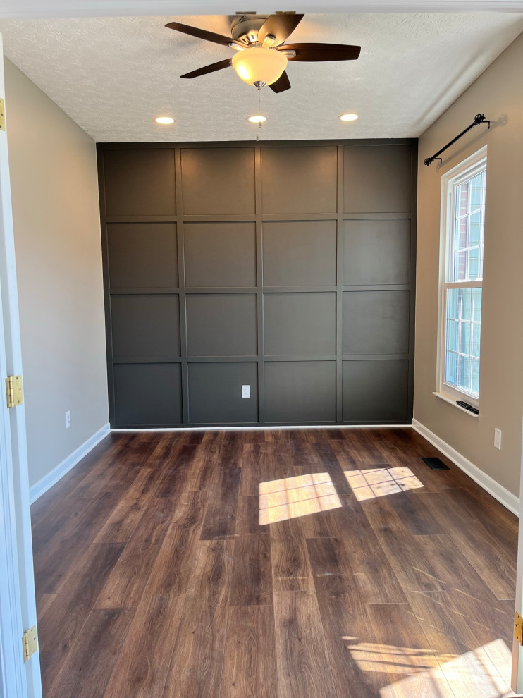 Imagen de despacho minimalista de tamaño medio con paredes grises, suelo vinílico, suelo marrón y boiserie