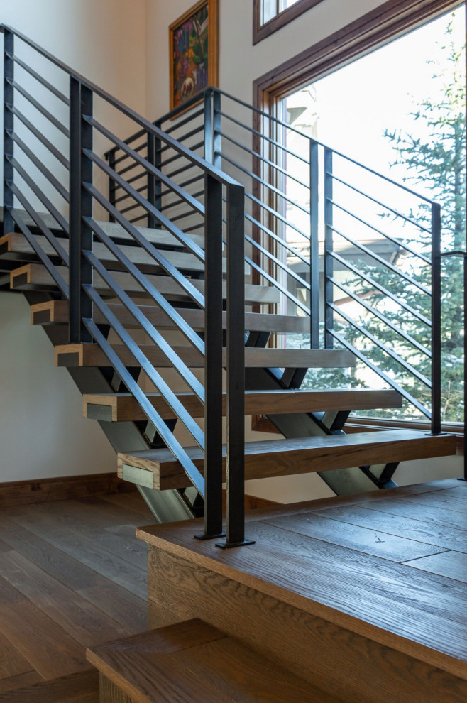 Diseño de escalera en L clásica renovada grande sin contrahuella con escalones de madera y barandilla de metal