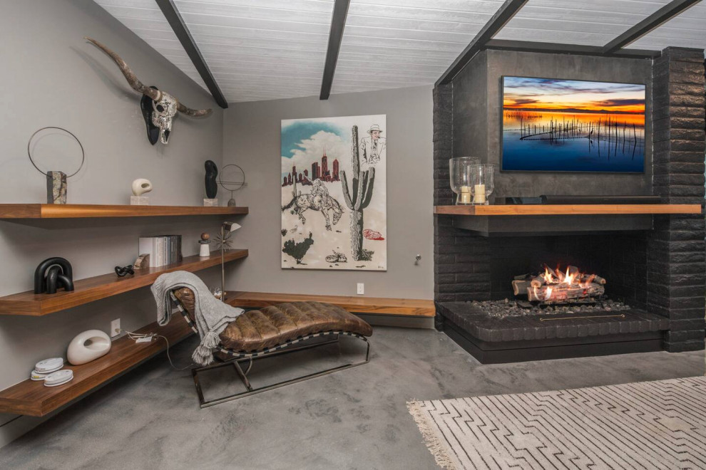 Large living room in Other with black walls, concrete floors, a standard fireplace, a brick fireplace surround, a wall-mounted tv, grey floor and exposed beam.
