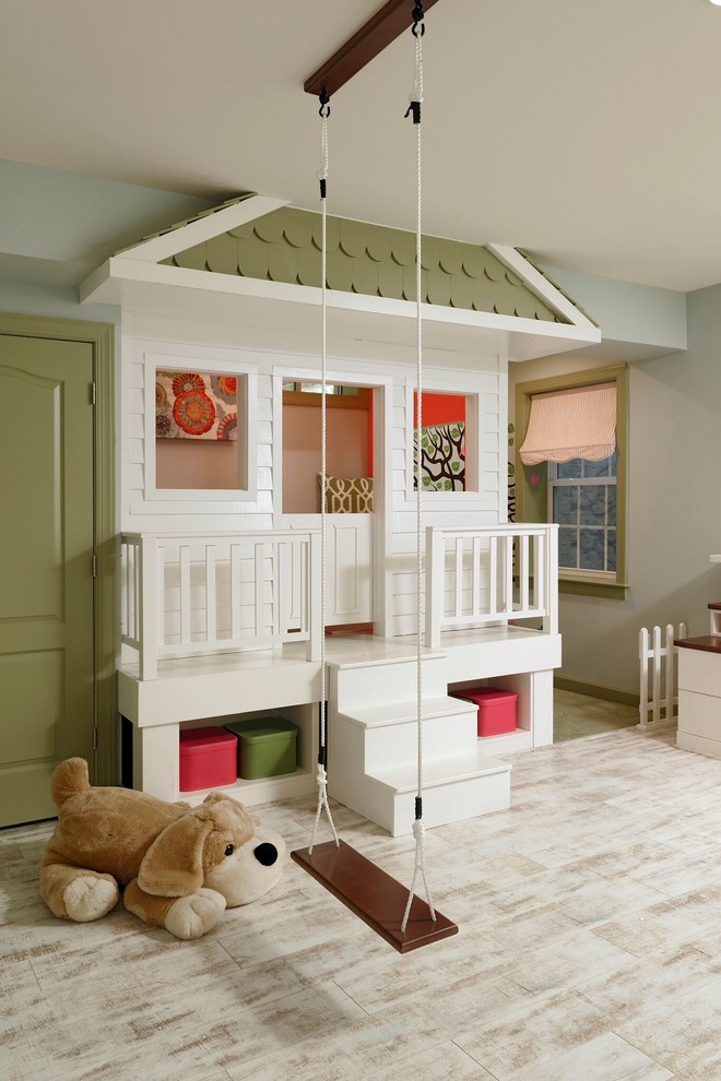 Creative and Unique Playroom - A perfect playroom space for two young girls to grow into.  The space contains a custom made playhouse, complete with hidden trap door, custom built in benches with plenty of toy storage and bench cushions for reading, lounging or play pretend.  In order to mimic an outdoor space, we added an indoor swing.  The side of the playhouse has a small soft area with green carpeting to mimic grass, and a small picket fence.  The tree wall stickers add to the theme.  A huge highlight to the space is the custom designed, custom built craft table with plenty of storage for all kinds of craft supplies.  The rustic laminate wood flooring adds to the cottage theme.
Bob Narod Photography