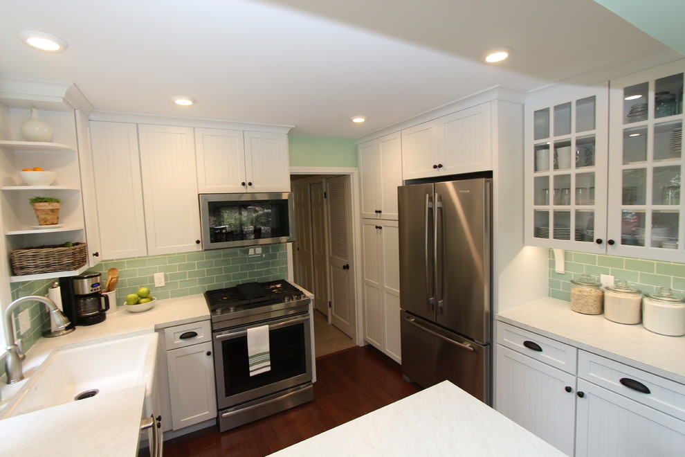 Photo of a mid-sized transitional u-shaped separate kitchen in Grand Rapids with an undermount sink, beaded inset cabinets, white cabinets, laminate benchtops, green splashback, glass tile splashback, stainless steel appliances, medium hardwood floors and a peninsula.
