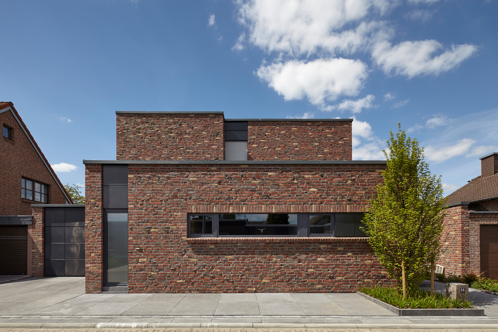 Industrial Einfamilienhaus mit Backsteinfassade, brauner Fassadenfarbe und Flachdach in Köln