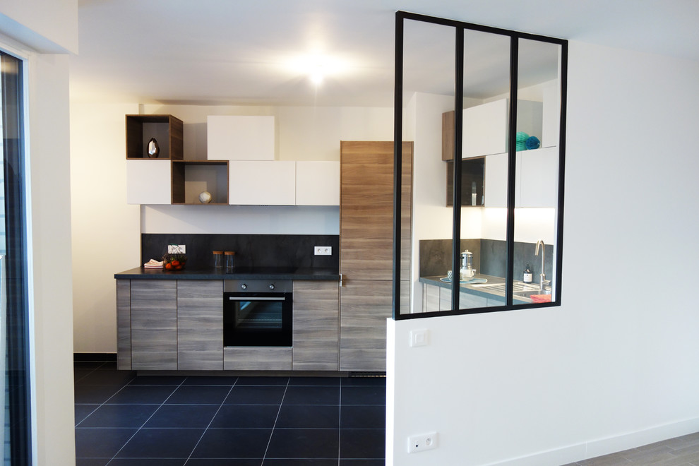 This is an example of a mid-sized contemporary l-shaped open plan kitchen in Paris with a single-bowl sink, flat-panel cabinets, medium wood cabinets, laminate benchtops, metallic splashback, metal splashback, panelled appliances, ceramic floors and no island.