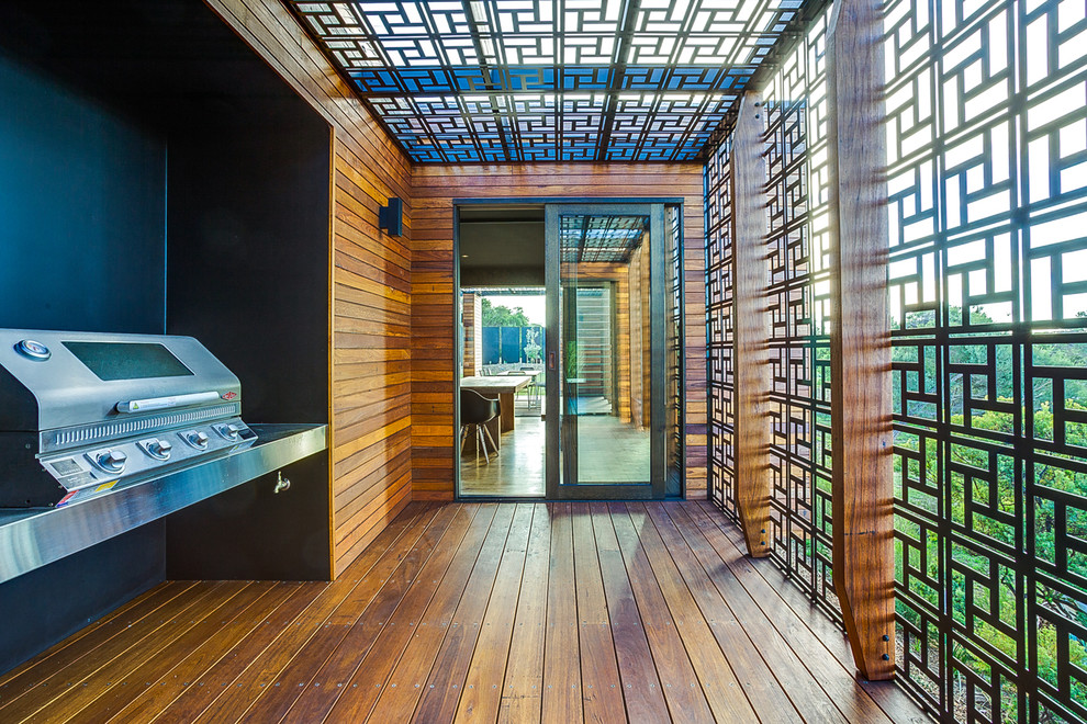 Photo of a mid-sized asian side yard deck in Melbourne with an outdoor kitchen and a pergola.
