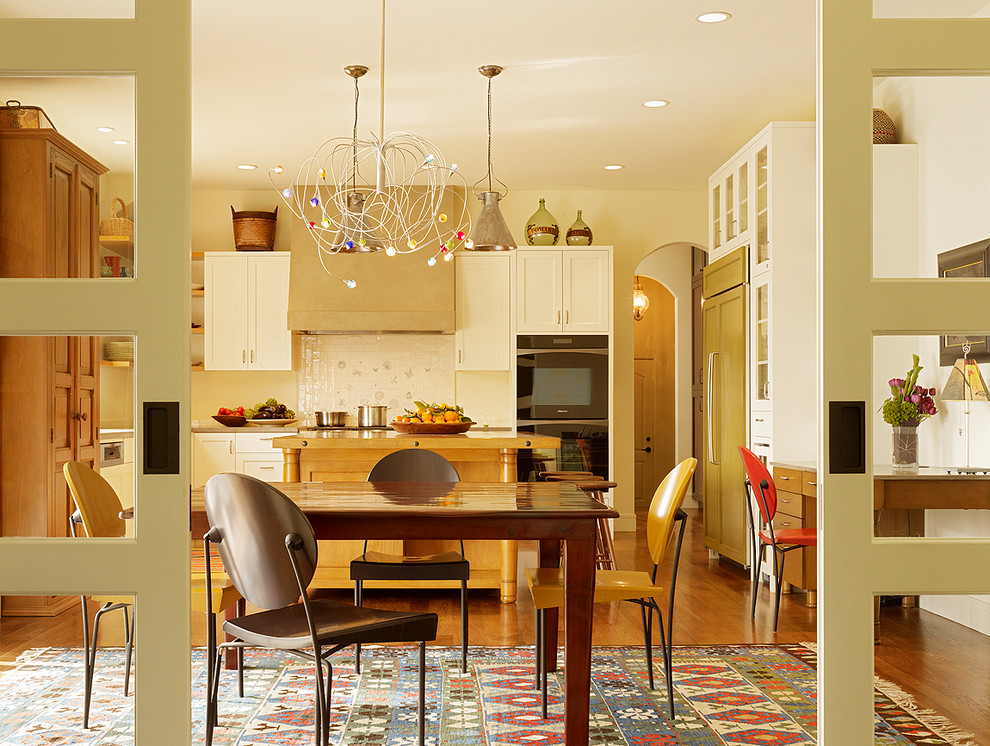 Inspiration for a modern eat-in kitchen in San Francisco with shaker cabinets, white cabinets, white splashback and black appliances.