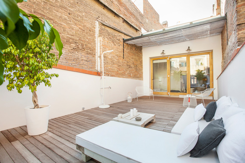 This is an example of a mid-sized mediterranean deck in Barcelona with an awning.