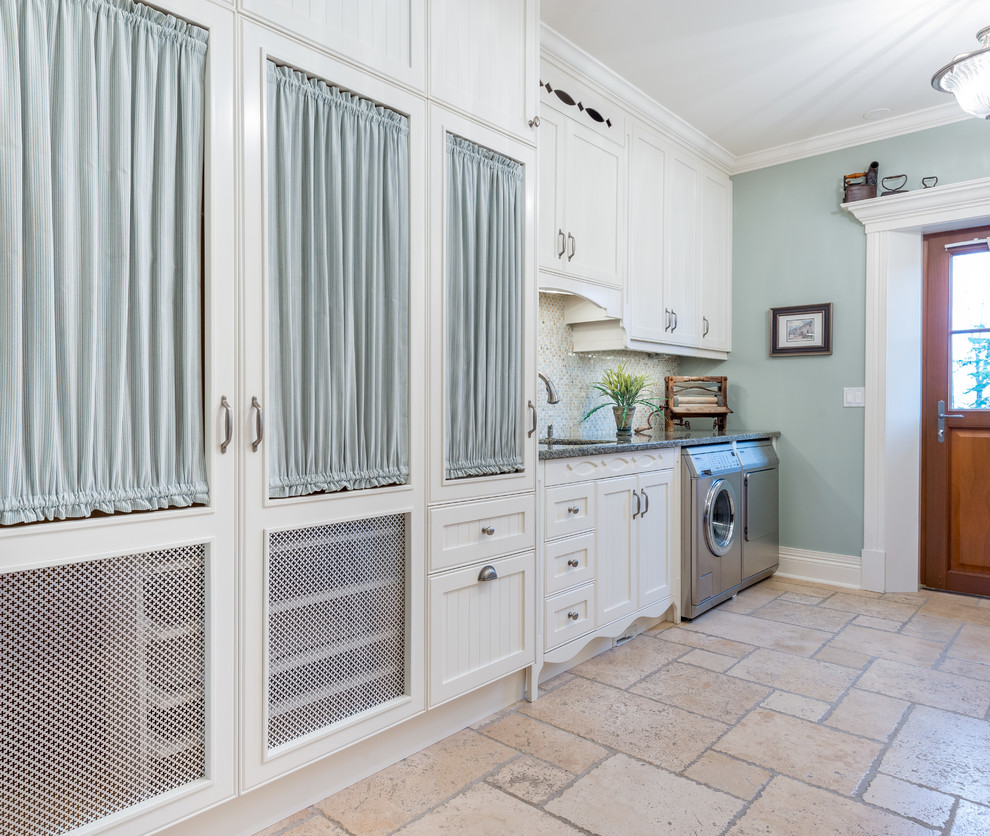 Design ideas for a mid-sized transitional single-wall dedicated laundry room in Ottawa with shaker cabinets, white cabinets, blue walls, limestone floors, a side-by-side washer and dryer, an undermount sink and beige floor.
