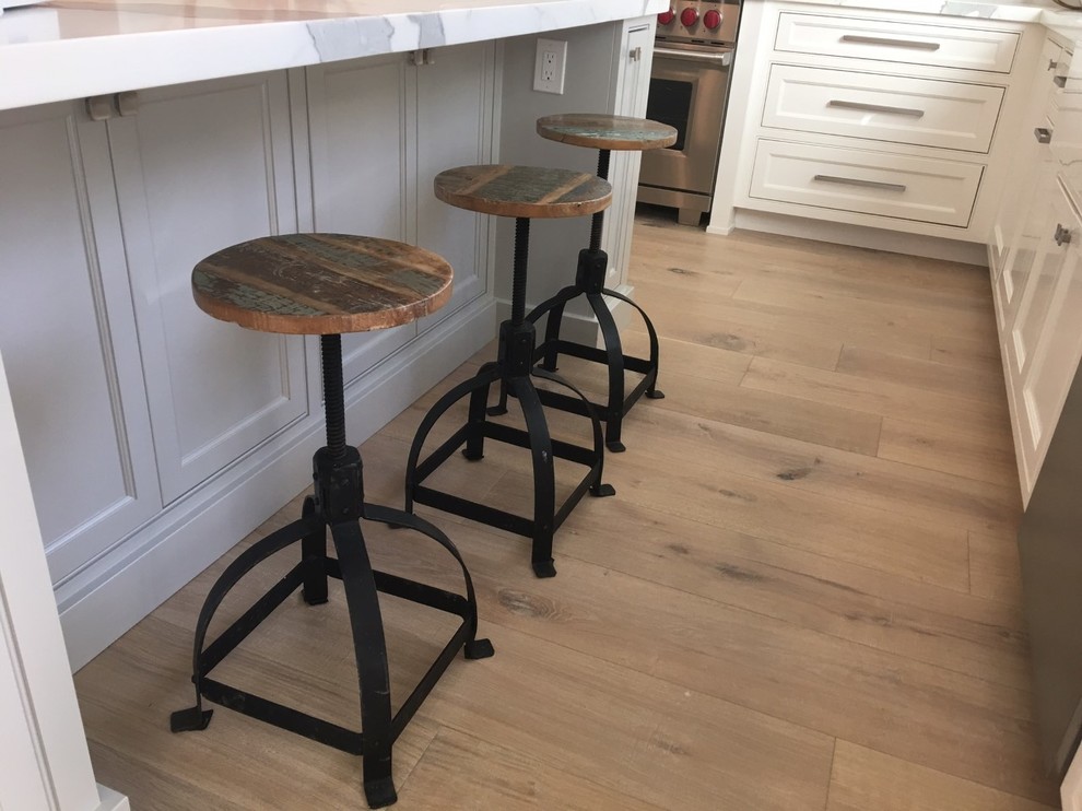 Inspiration for a large transitional u-shaped light wood floor and beige floor eat-in kitchen remodel with shaker cabinets, white cabinets, marble countertops, an island, a double-bowl sink, white backsplash, porcelain backsplash and stainless steel appliances