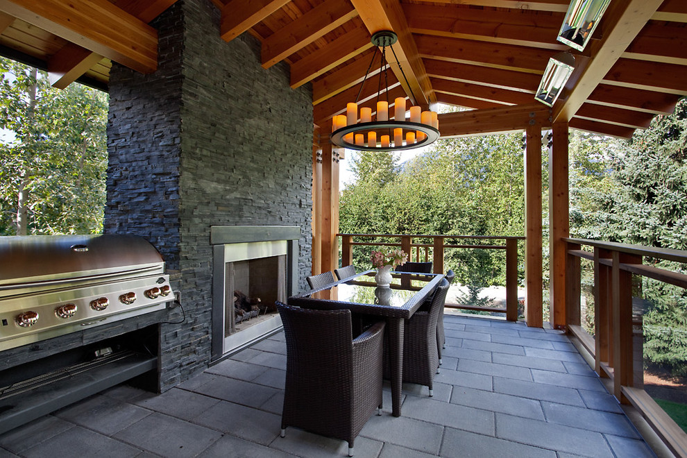 Inspiration for a large arts and crafts backyard verandah in Vancouver with a fire feature, concrete pavers and a roof extension.