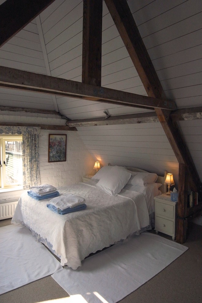 Design ideas for a mid-sized country loft-style bedroom in Dorset with carpet and no fireplace.