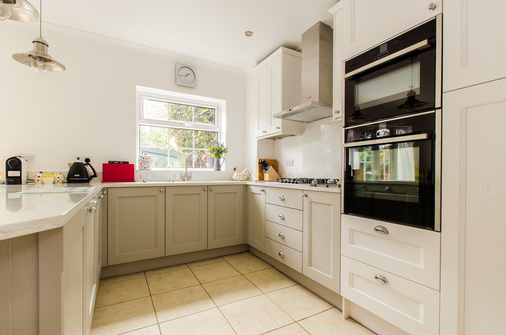 Photo of a traditional u-shaped kitchen in Kent with shaker cabinets, grey cabinets, quartz worktops and a breakfast bar.