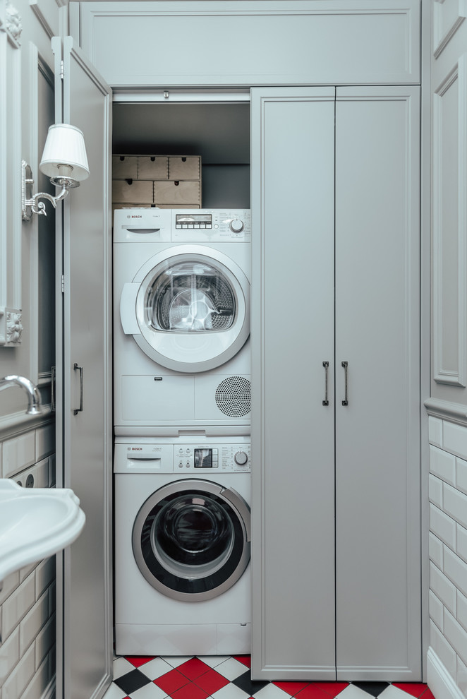 Design ideas for a transitional laundry cupboard in Other with a stacked washer and dryer.