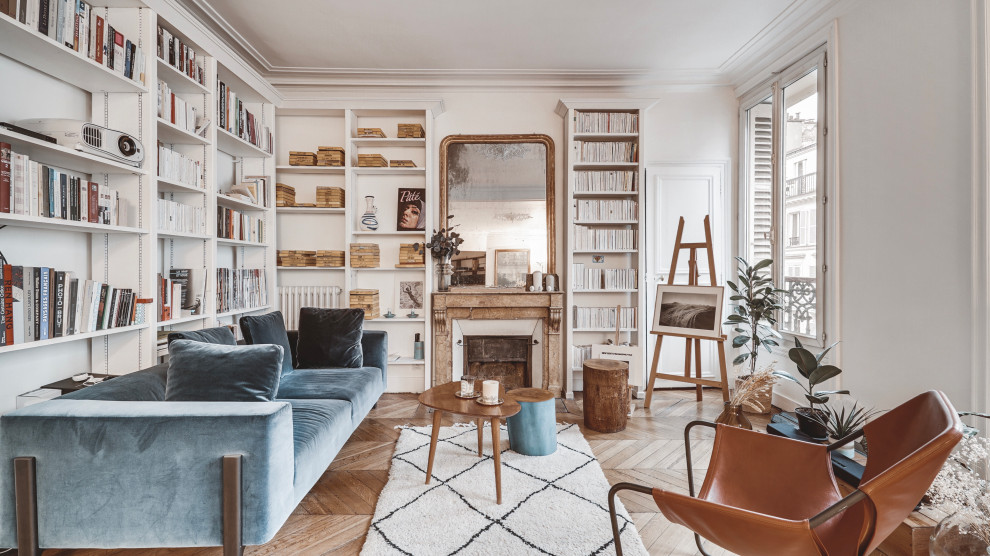 Mid-sized scandinavian open concept living room in Paris with white walls, medium hardwood floors, brown floor, a library, a standard fireplace, a stone fireplace surround, no tv and decorative wall panelling.