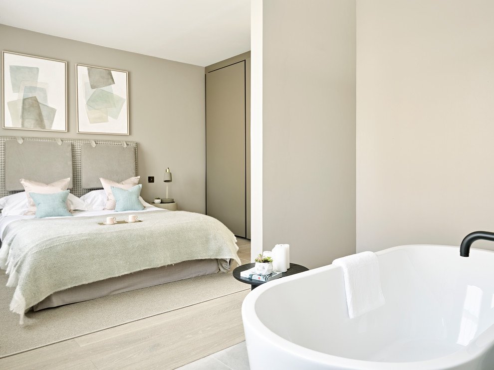 Mid-sized contemporary master bathroom in London with grey walls and a freestanding tub.
