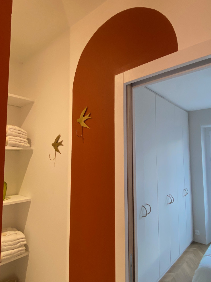 Exemple d'une petite salle de bain chic avec WC suspendus, un carrelage blanc, des carreaux de céramique, un mur rouge, carreaux de ciment au sol, un lavabo posé, un plan de toilette en bois, un sol multicolore, une cabine de douche à porte battante, du carrelage bicolore et meuble simple vasque.