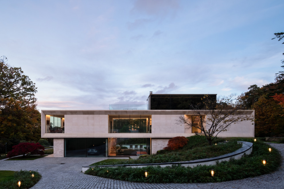 Diseño de fachada de casa beige minimalista grande de tres plantas con revestimiento de piedra y tejado plano