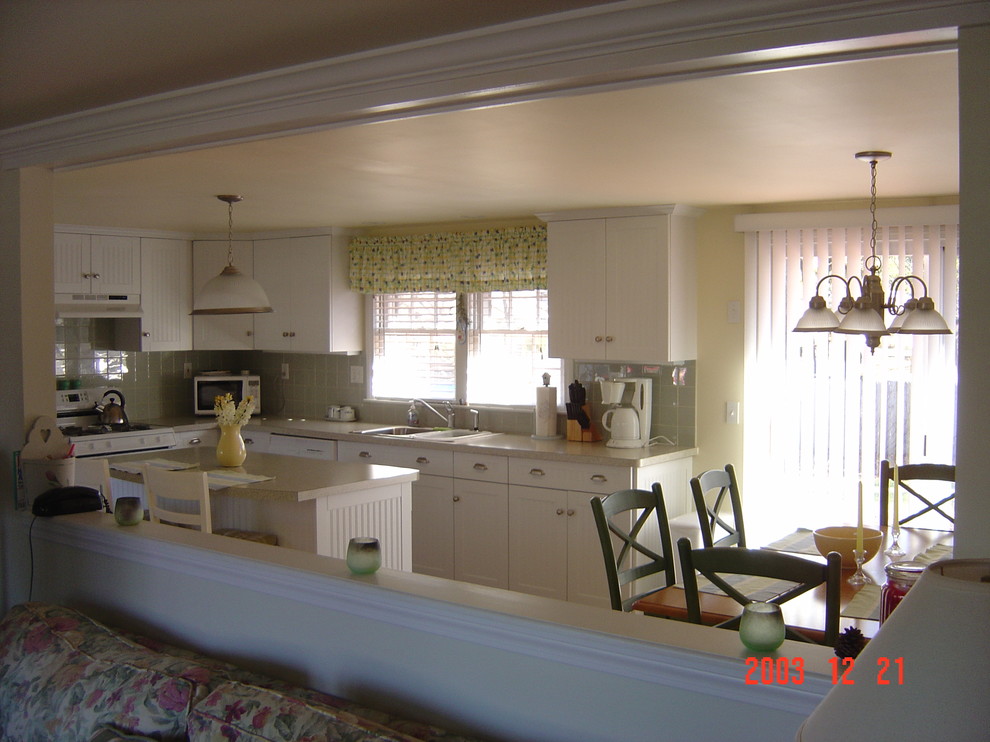 Photo of a mid-sized beach style l-shaped eat-in kitchen in Boston with a drop-in sink, beaded inset cabinets, white cabinets, laminate benchtops, ceramic splashback and light hardwood floors.