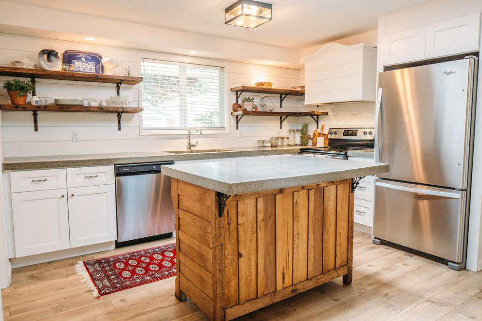 This is an example of a mid-sized eclectic l-shaped kitchen in Seattle with an undermount sink, shaker cabinets, white cabinets, concrete benchtops, white splashback, ceramic splashback, stainless steel appliances, with island, multi-coloured floor and grey benchtop.