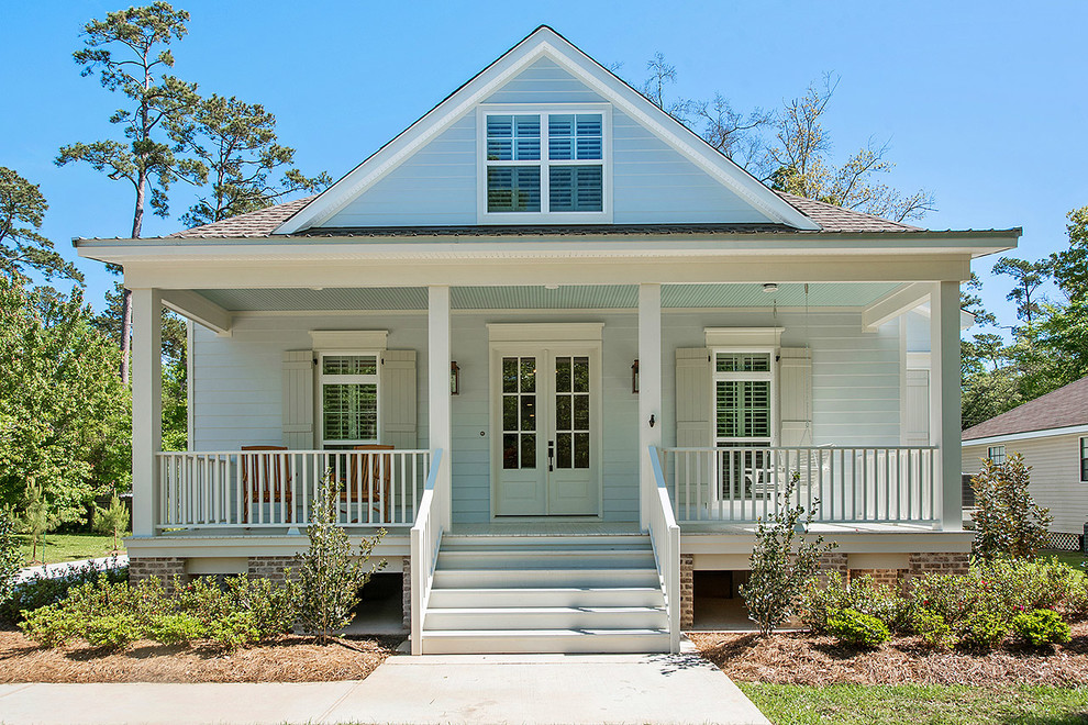 Photo of a mid-sized arts and crafts two-storey blue exterior in New Orleans with wood siding and a gable roof.