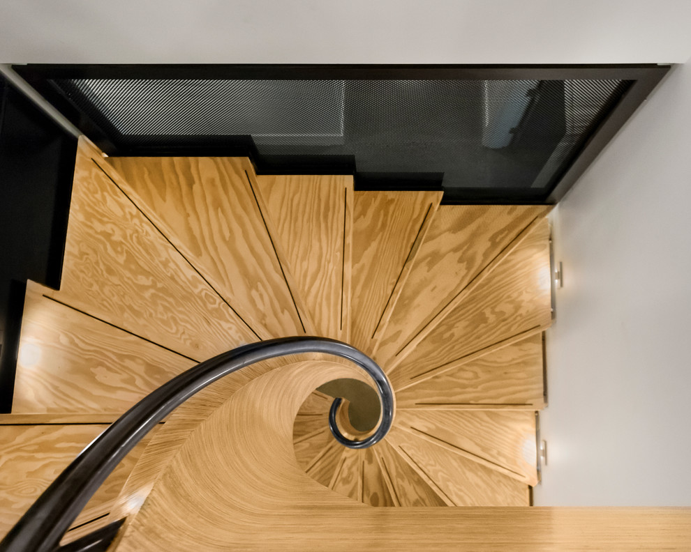 Inspiration for a large modern wood spiral staircase in Portland with wood risers and metal railing.