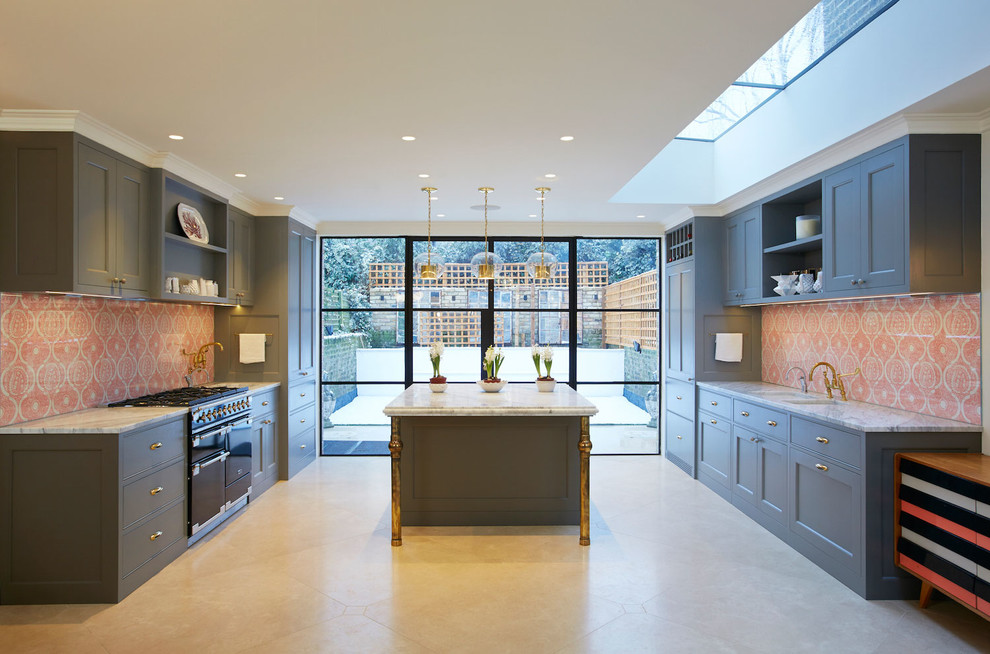 Photo of a large transitional kitchen in London with blue cabinets, red splashback and with island.