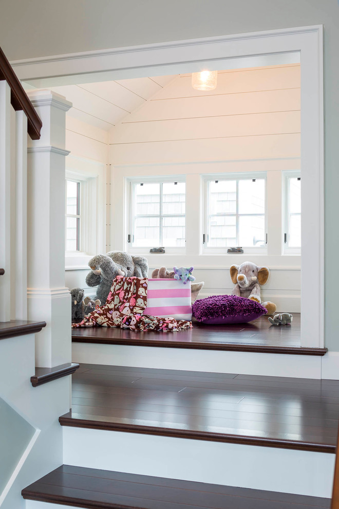 Small transitional gender-neutral kids' playroom in Seattle with white walls, dark hardwood floors and brown floor.