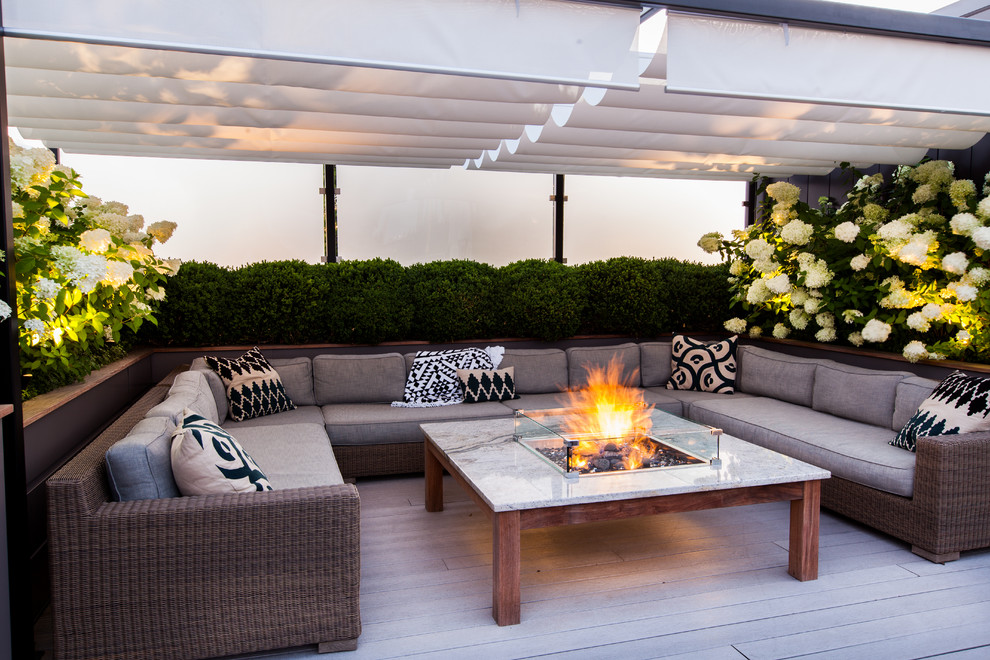 Photo of a mid-sized contemporary rooftop deck in Chicago with a fire feature and a pergola.