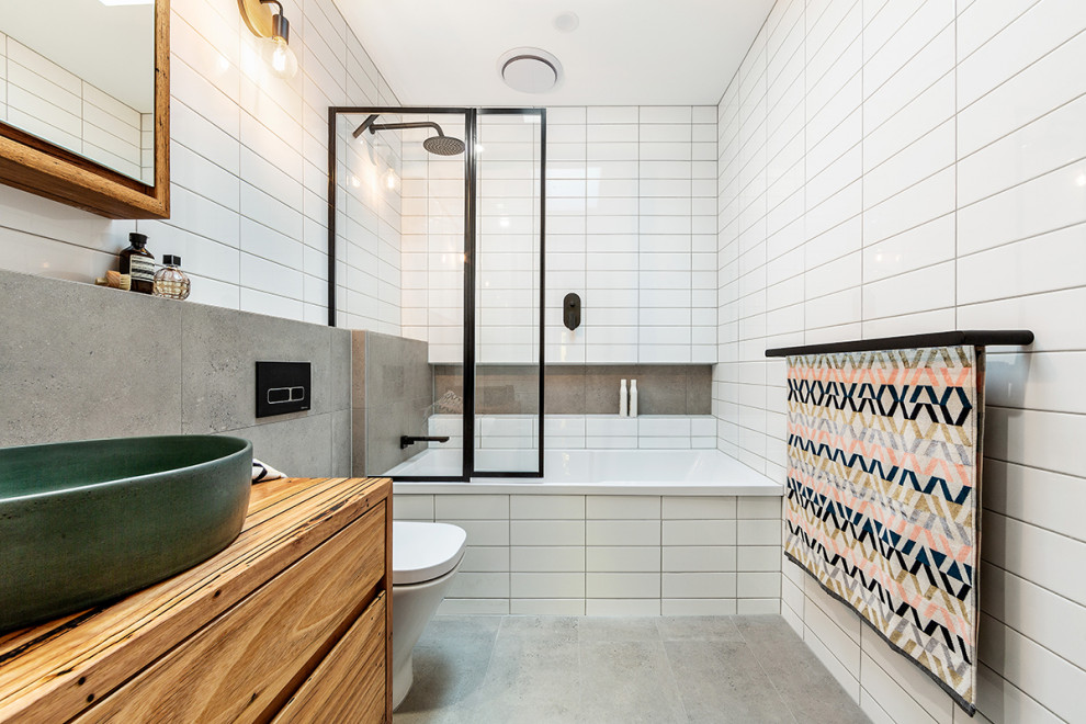 Design ideas for a small contemporary master bathroom in Melbourne with flat-panel cabinets, medium wood cabinets, a drop-in tub, white tile, a vessel sink, wood benchtops, grey floor and brown benchtops.