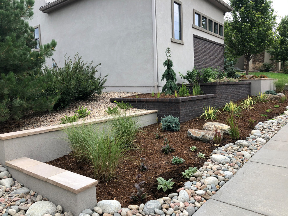 Moderner Garten neben dem Haus mit Blumenbeet und Flusssteinen in Denver
