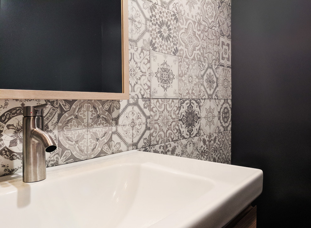 Photo of a small scandinavian powder room in Orange County with flat-panel cabinets, light wood cabinets, a one-piece toilet, black and white tile, ceramic tile, grey walls, concrete floors, an integrated sink, grey floor and white benchtops.